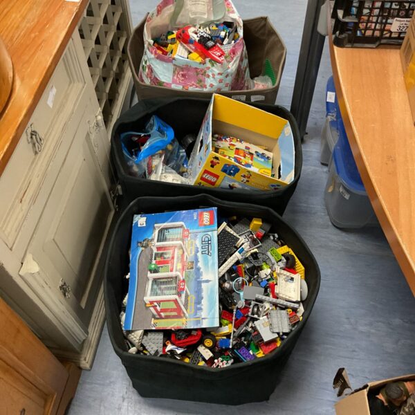 Three boxes filled with a mixed assortment of Lego building blocks.