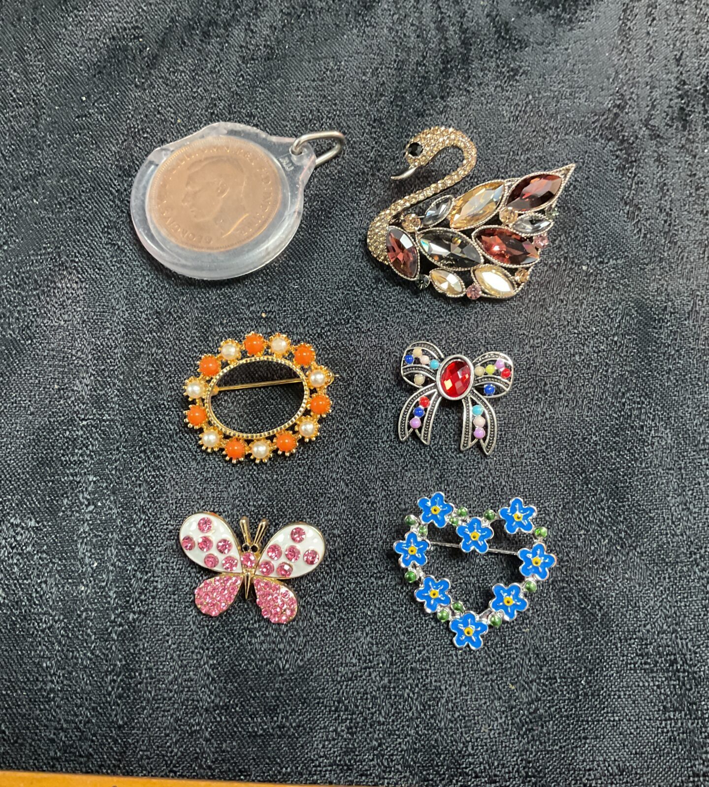 Five costume jewellery brooches and penny pendant