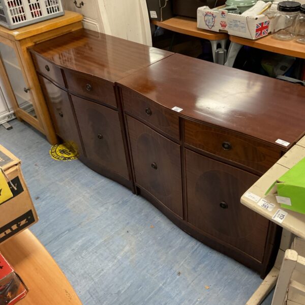 Pair of reproduction mahogany serpentine hall cabinets for storage.