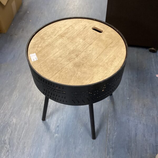 Vintage round sewing table with perforated wooden top and tapered legs.