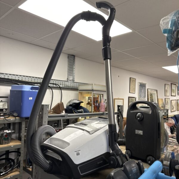 Miele Blizzard CX1 Stowaway cylinder vacuum cleaner in a workshop setting.
