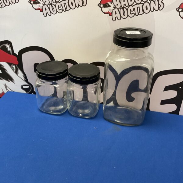 Three glass storage jars