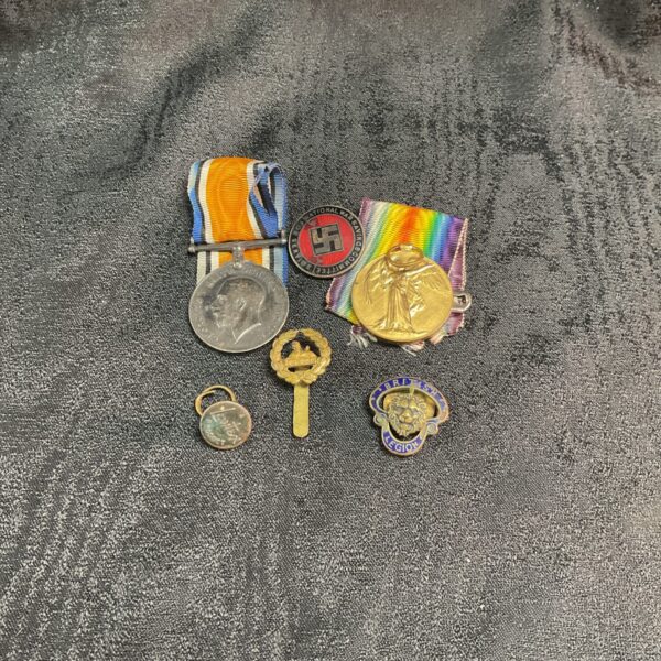 WWI medals and badges including a Worcester Regiment cap badge.