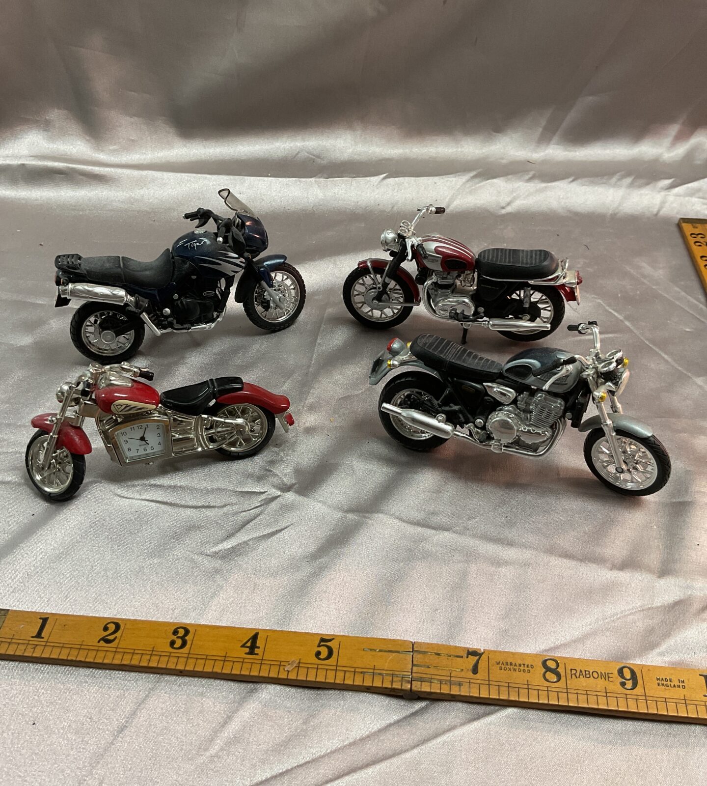 Three diecast model triumph motorcycles and motorcycle desk clock