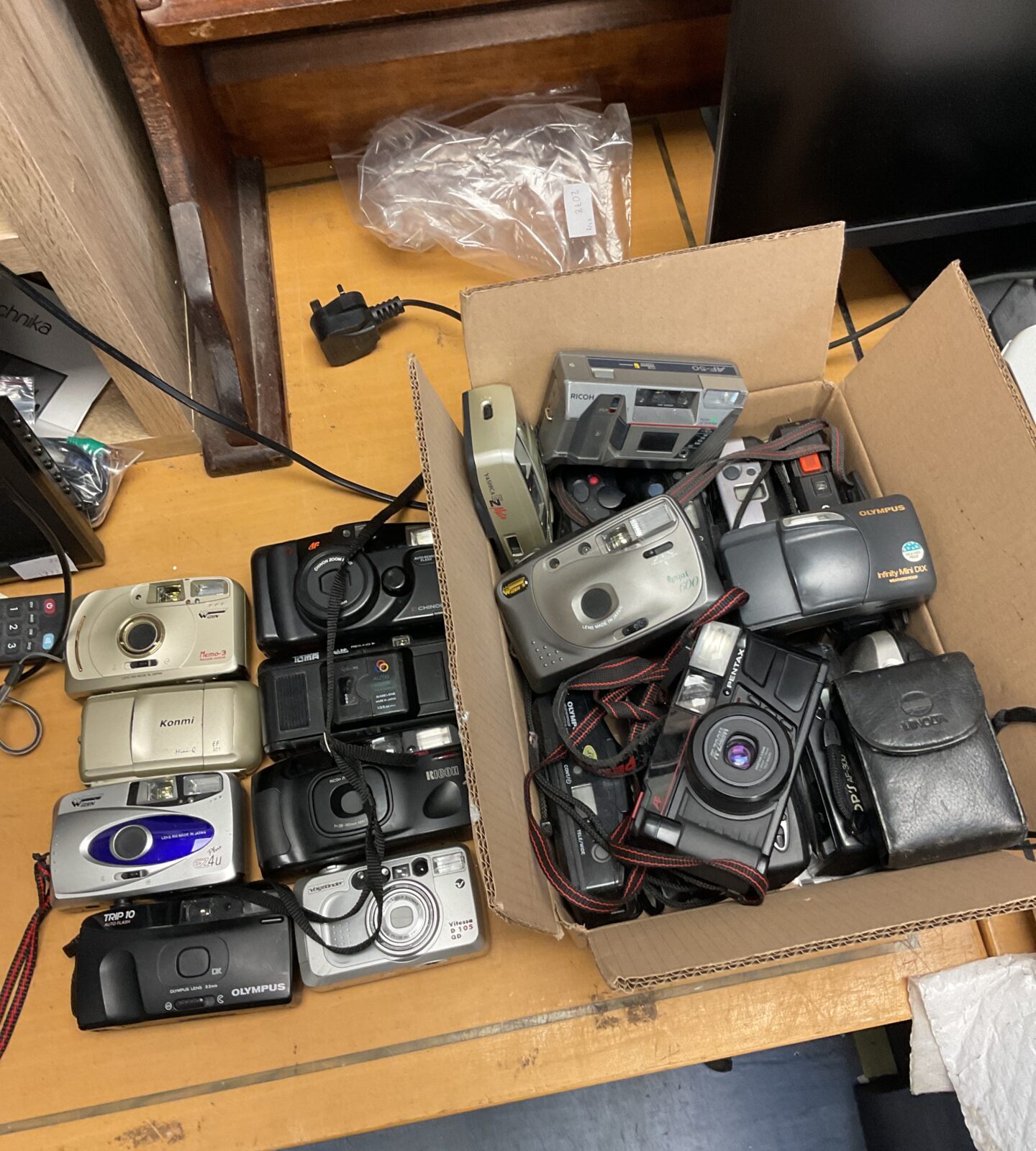 Box full of 35mm film cameras including olympus