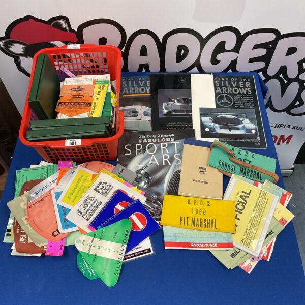 Vintage motor racing steward ephemera collection with colourful flags and badges.