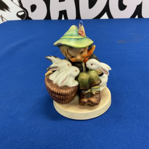 Vintage Hummel figurine of a boy playing with rabbits.