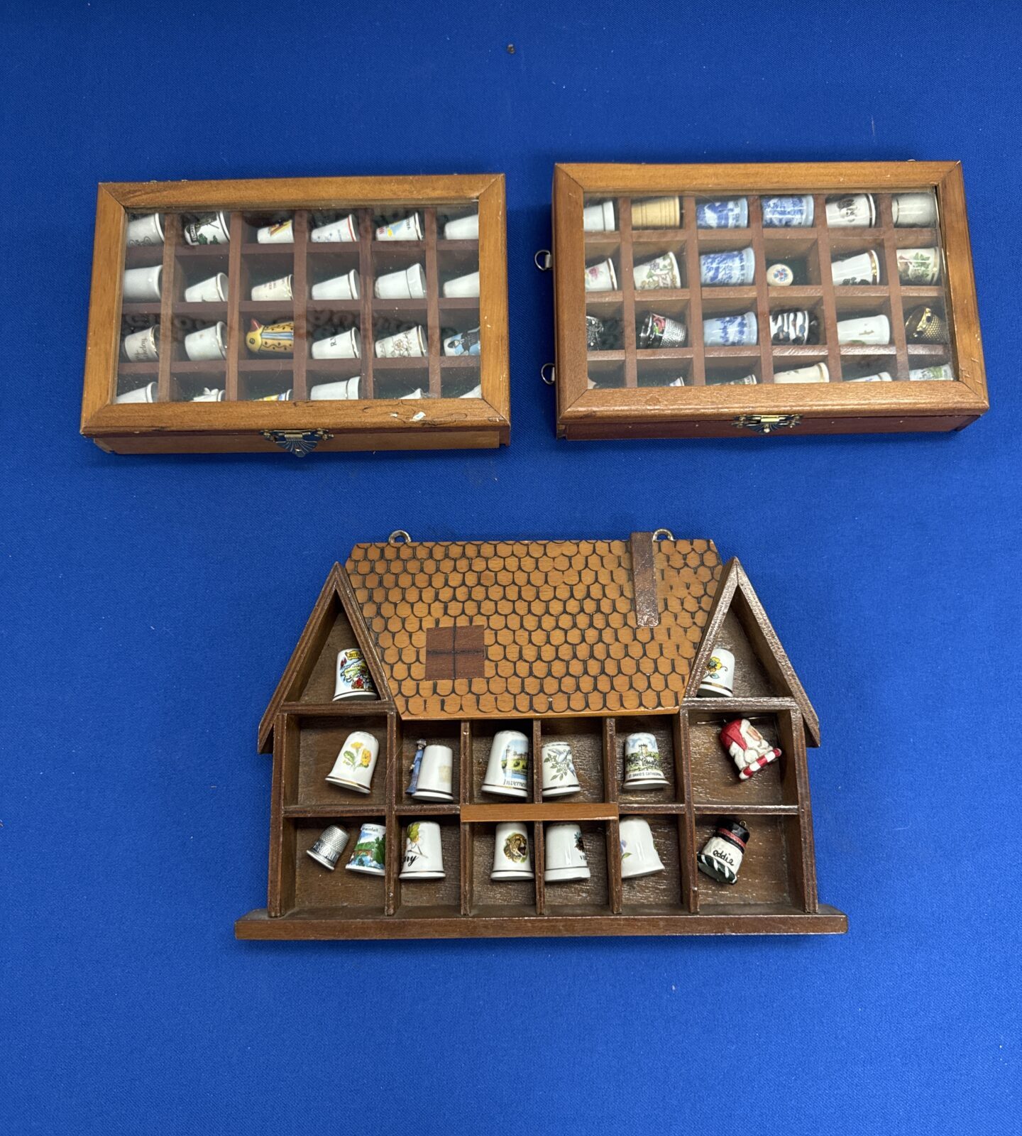 Three small display cases with thimbles contents
