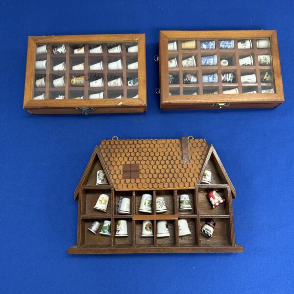 Three small display cases with thimbles contents