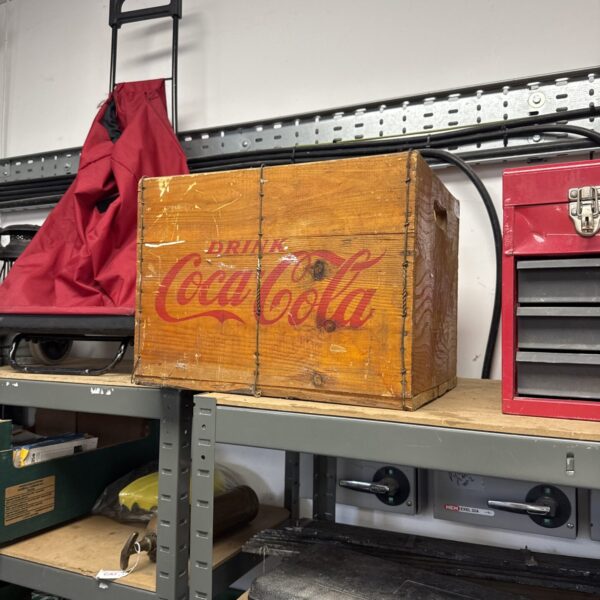 Vintage wooden Coca Cola crate with bold red lettering.