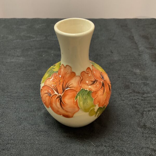 Moorcroft vase with vibrant hibiscus floral pattern.
