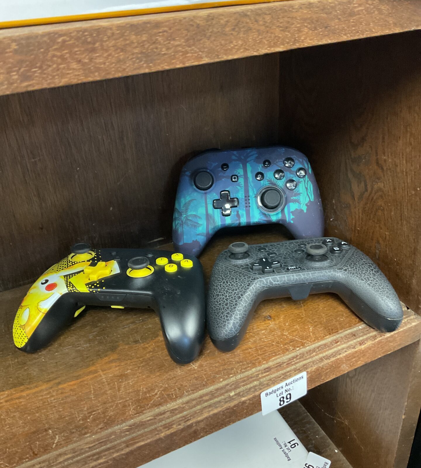 Three nintendo switch controllers including power a pikachu switch controller