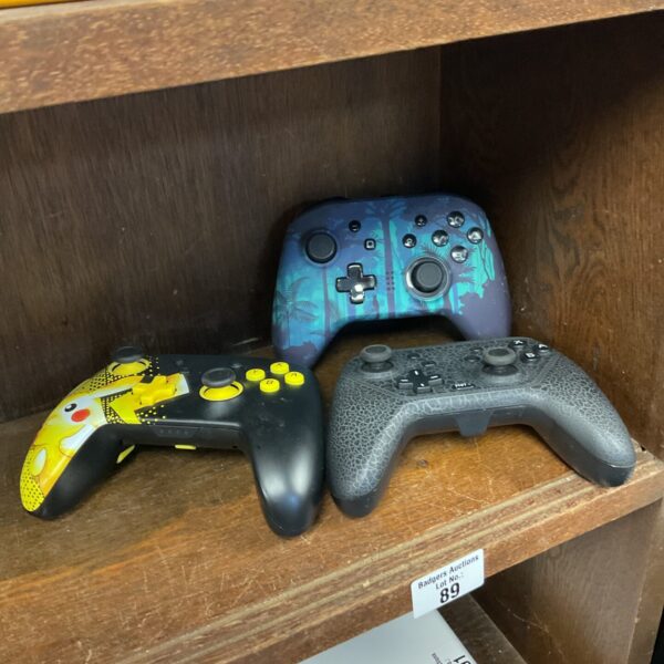Three nintendo switch controllers including power a pikachu switch controller