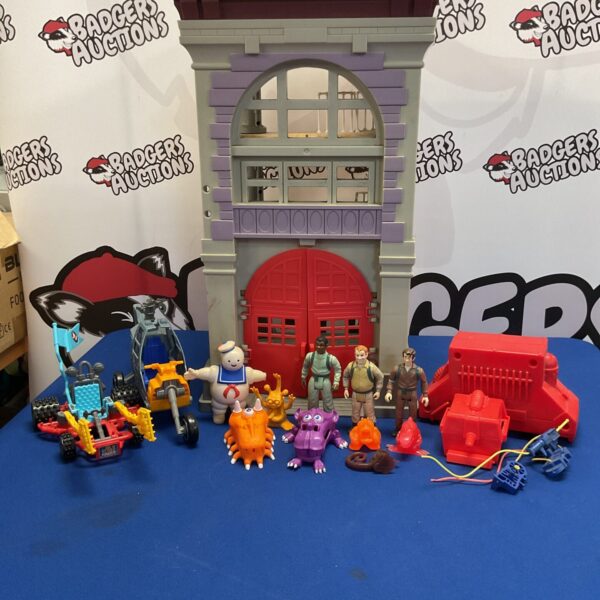 Vintage 1980s Ghostbusters fire station playset with figures and vehicles.