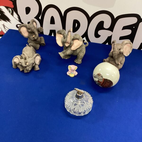 Vintage ceramic elephant figurines displayed on a patterned surface.