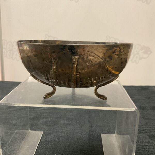 Antique silver relief bowl on display, detailed relief decoration.