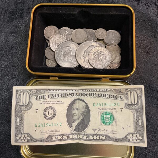 Vintage tin filled with American coins and a ten dollar bill.