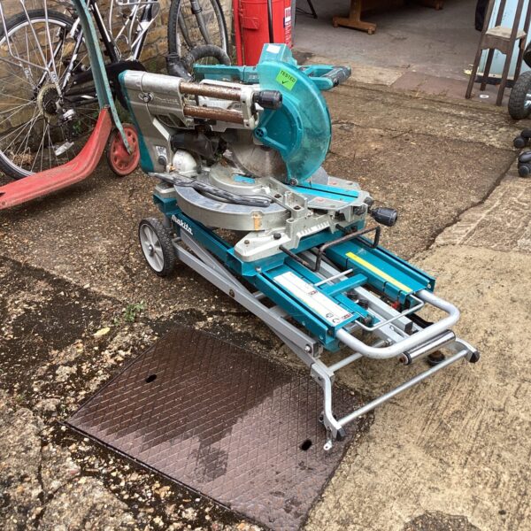 Makita battery chop saw on stand, portable metal cutting tool.
