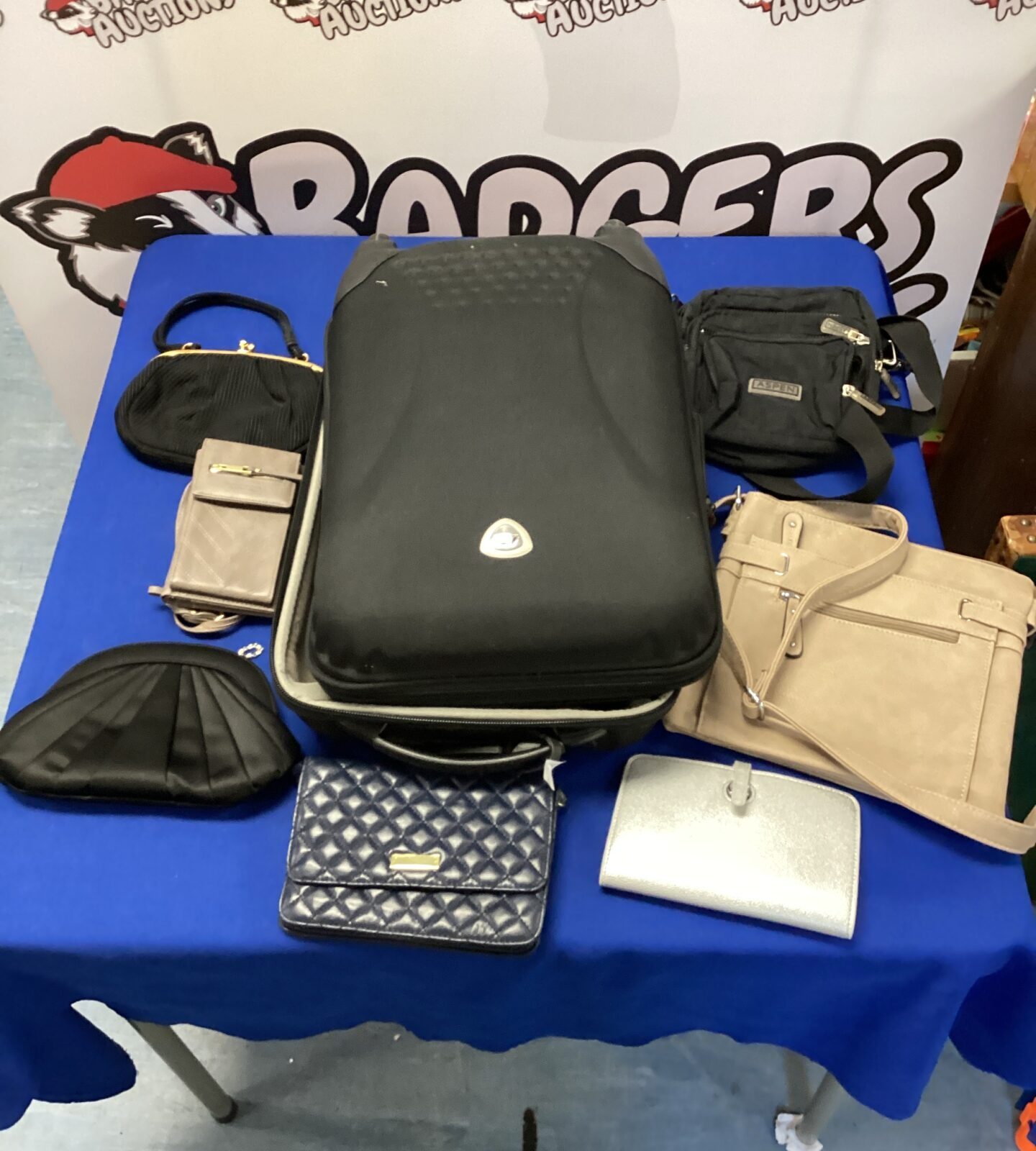 Suitcase with assortment of ladies handbags