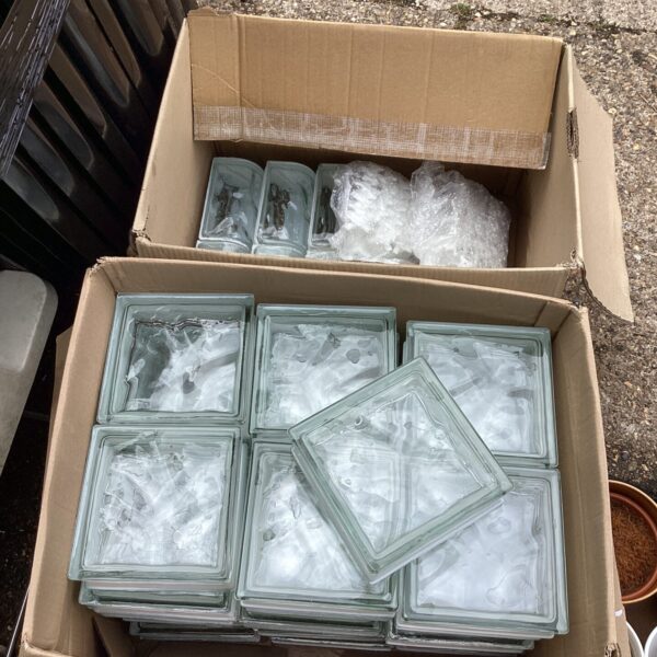 Clear glass bricks with spacers in a cardboard box.