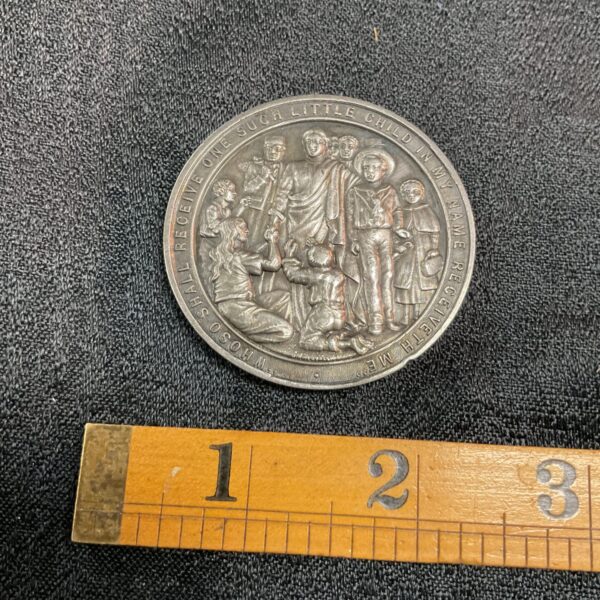 Vintage silver Barnardo's medal obverse with children scene.