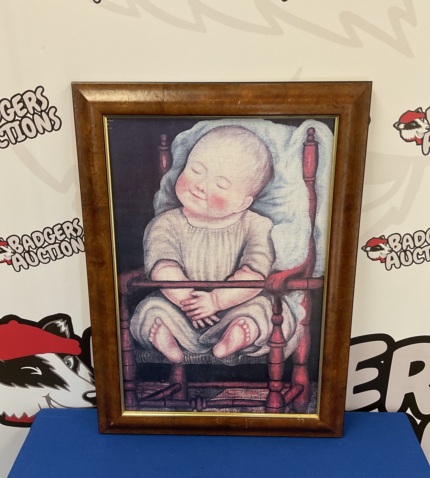 Framed print of a baby in red chair by anonymous American artist
