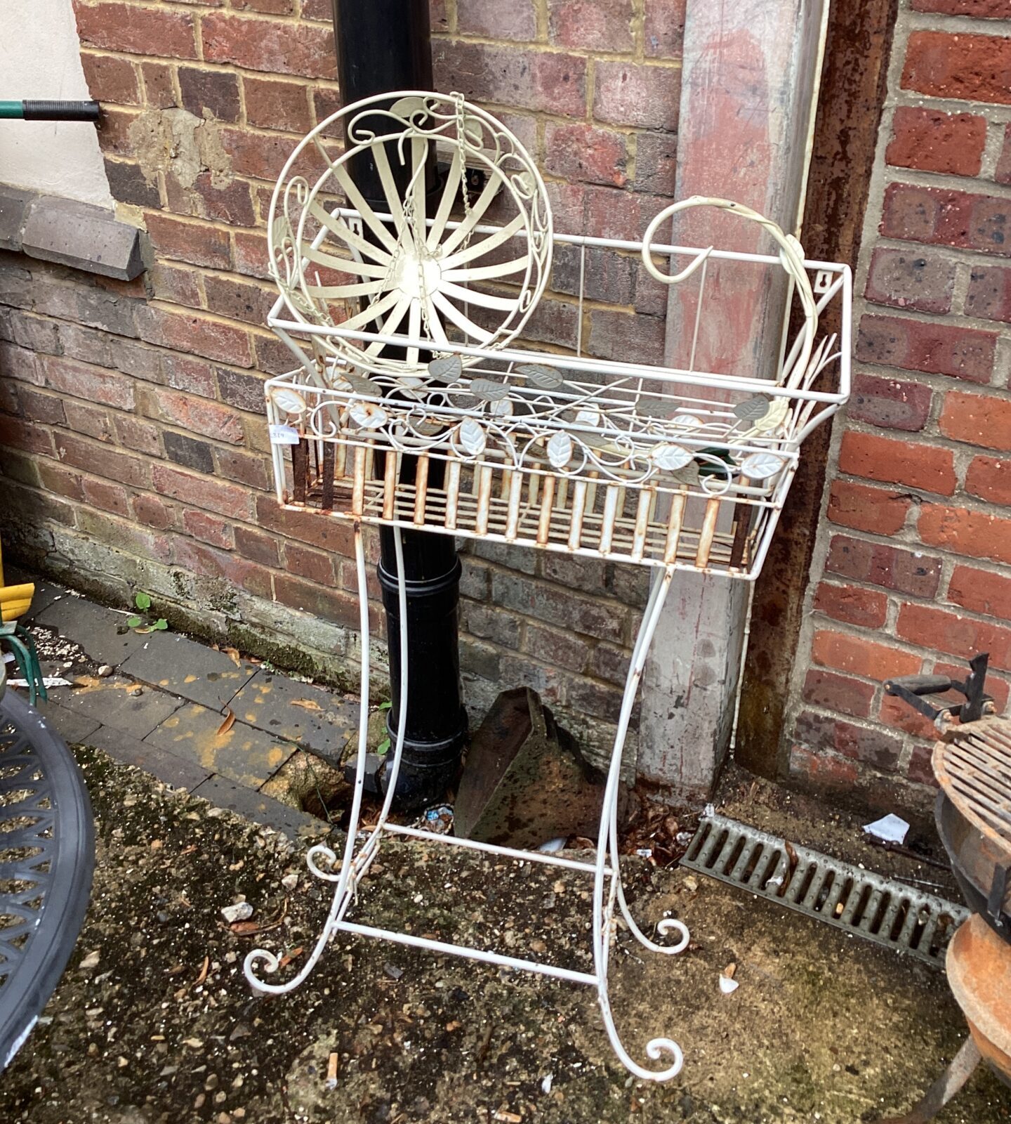 White metal flower trough with hanging basket