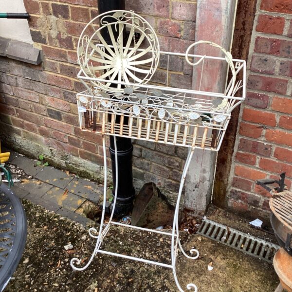 White metal flower trough with hanging basket