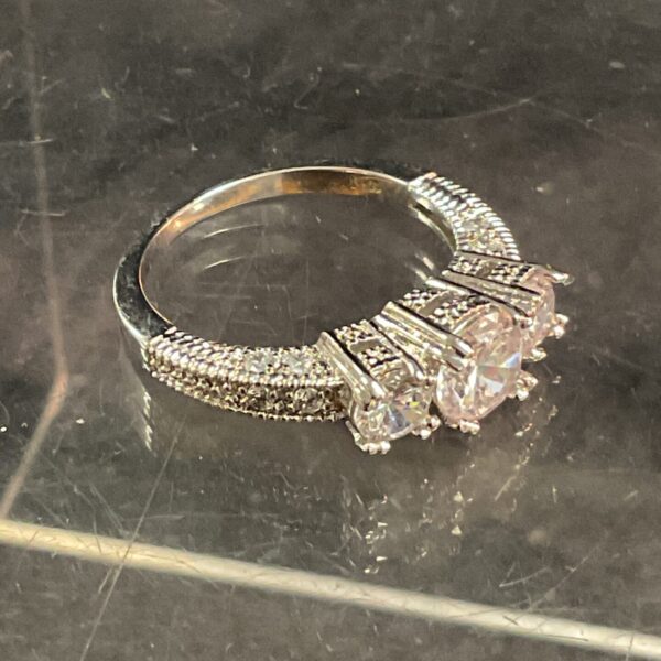 10kt white metal ring with three cubic zirconia stones.