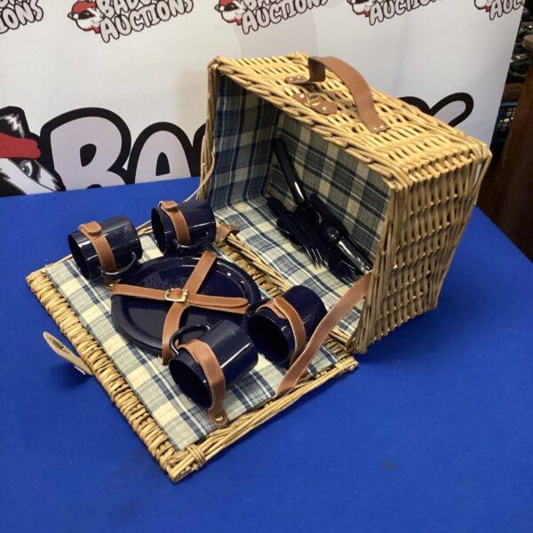 Vintage wicker picnic hamper with patterned lining and handle.