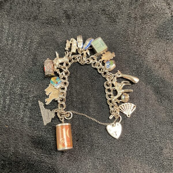 Vintage silver charm bracelet with multiple charms and a padlock clasp.