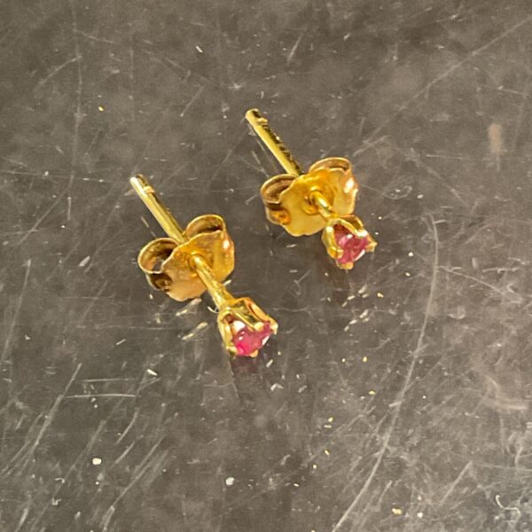 Close-up of 9ct gold red stone stud earrings.