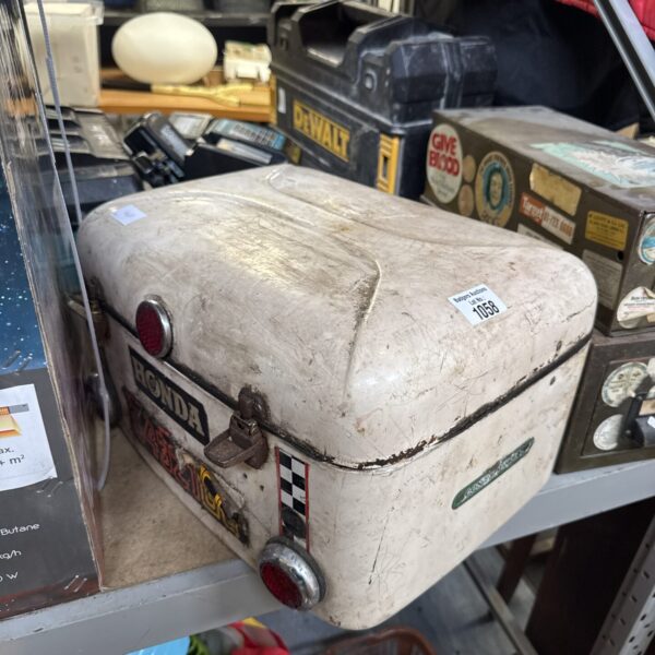 Vintage Honda motorcycle pillion box with red rear light.