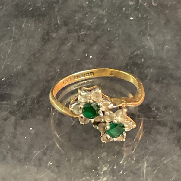 9ct gold ring with emerald and diamond crossover design.