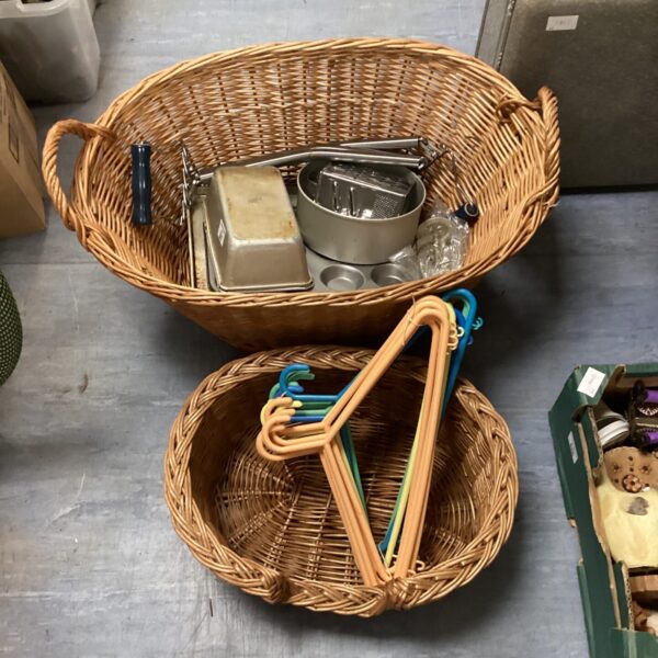 Two wicker baskets with assortment of baking trays & clothes hangers
