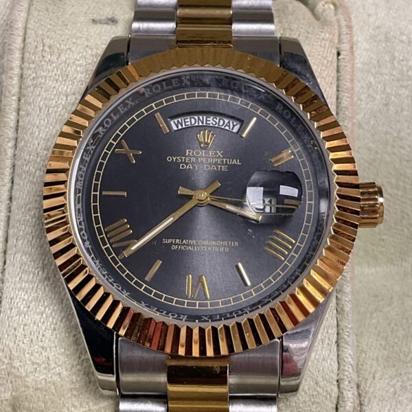 Front view of a gold and silver Rolex Day-Date reproduction watch.