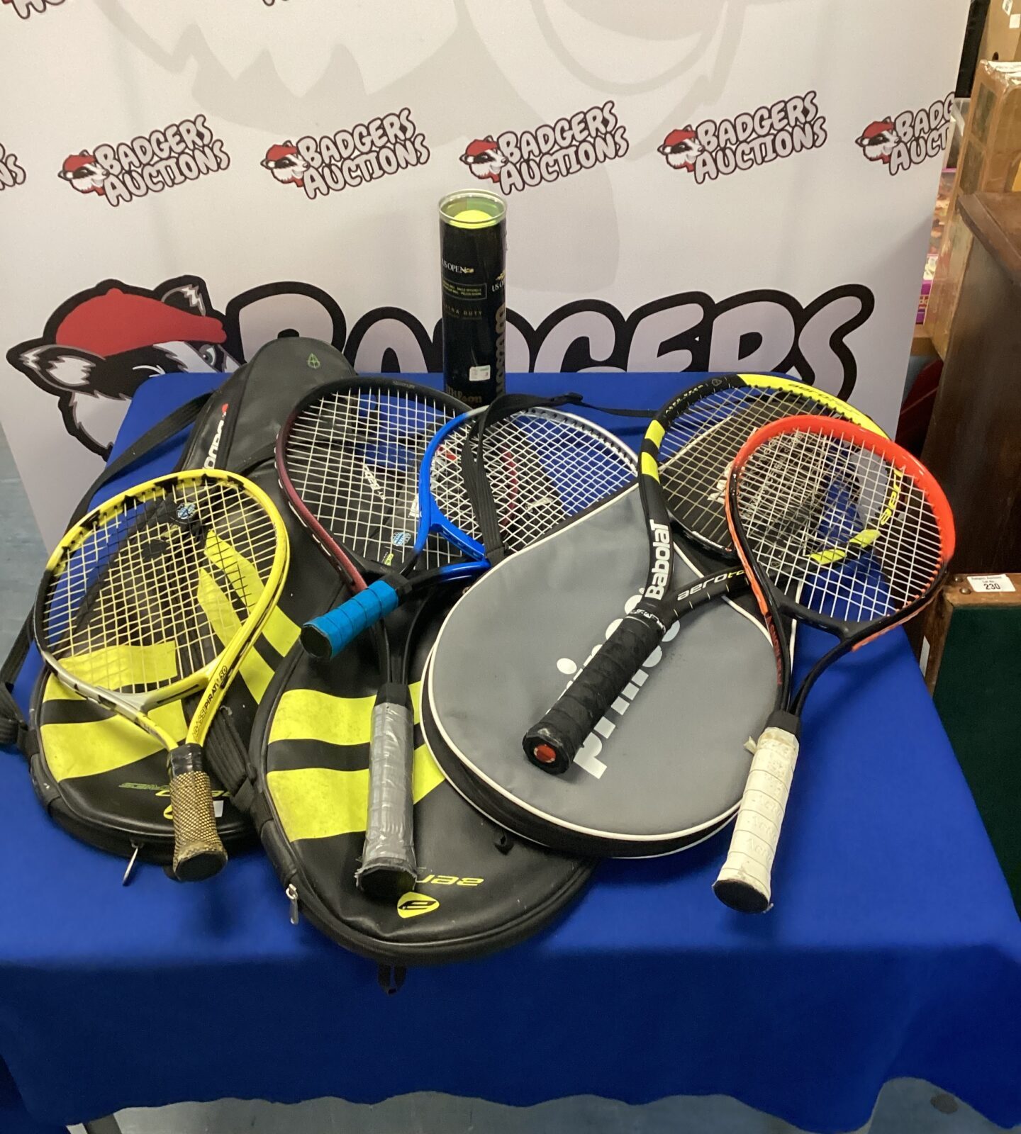 selection of tennis rackets in bags with balls