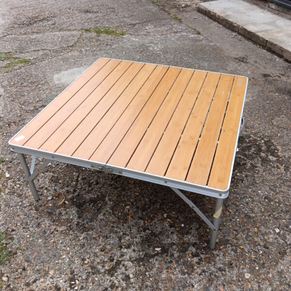 Portable Outwell camping folding table for outdoor use.