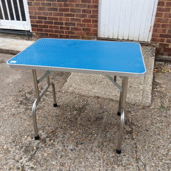 Blue folding table with steel frame, ideal for outdoor use.