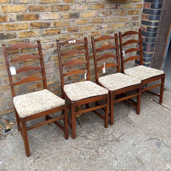 Set of four vintage Ercol ladder back chairs with patterned upholstery.