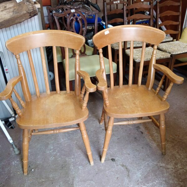 Pair of light oak carvery chairs with upholstered seats.