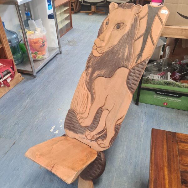 Detailed hand-carved African lion chair, a unique folk art piece.