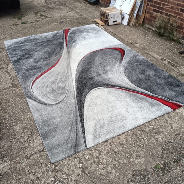 Large Merinos rug with abstract grey, silver, and red pattern.