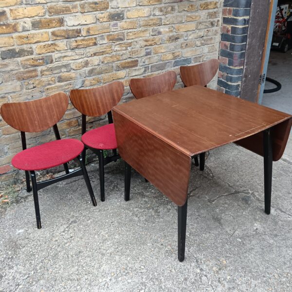 Vintage G-Plan dining set with teak table and red chairs.