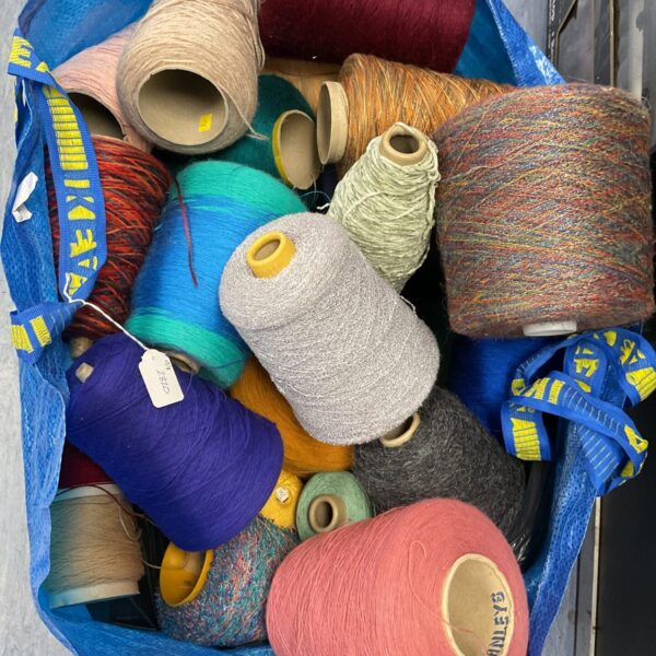 Colourful weaving yarn spools in a storage bag.