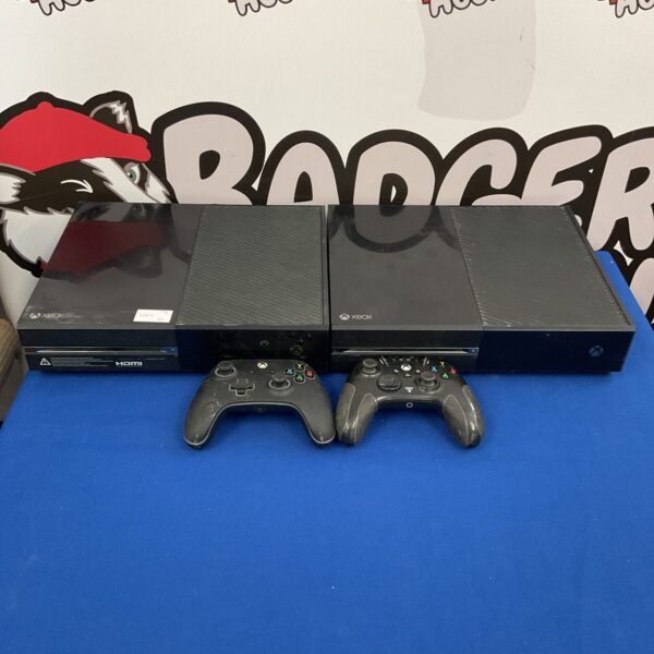 Two Xbox One consoles and controllers in a gaming bundle.