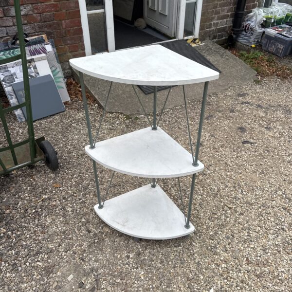 White three-tier corner shelf unit for display and storage.
