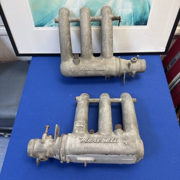Pair of vintage Maserati intake manifolds for classic car restoration.