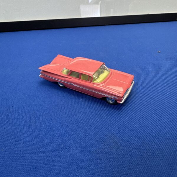 Red vintage Corgi Chevy Impala diecast toy car.