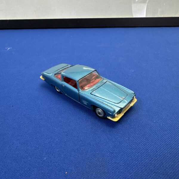 Blue vintage Corgi Ford Ghia diecast car on blue background.